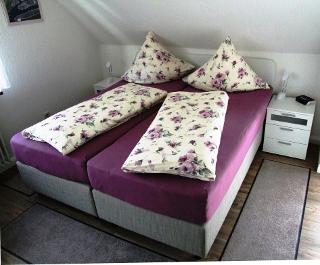 Das Schlafzimmer mit dem Boxspringbett und einem 2. Fernsehgerät