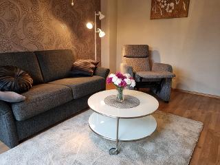 Wohnzimmer mit gemütlichem Sofa und Fernsehsessel